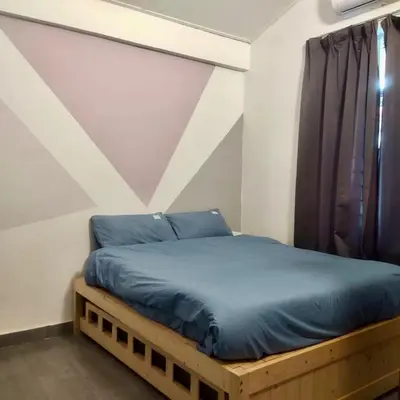 a bed with blue sheets in a room with a window at Happy Gather Homestay \u6b22\u805a\u9601 in Ipoh