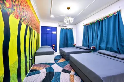 a bedroom with two beds and a painting on the wall at Penang Dream Banglo Sleeps 50 in Tanjung Bungah