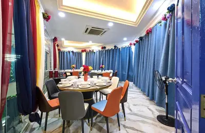 a dining room with a table and chairs and blue curtains at Penang Dream Banglo Sleeps 22 in Tanjung Bungah
