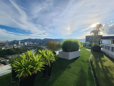 a green yard with potted plants on top of a building at Urban Suite - George Town in Jelutong