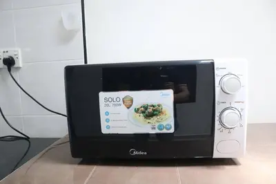 a microwave with a picture of a plate of food at Green Space Homestay Cozy Family(8-12pax) in Ipoh