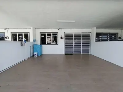 a large empty garage with doors and a tile floor at Nana's Sitiawan Home Stay, Victoria cottage in Sitiawan
