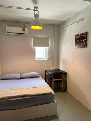 a bedroom with a bed and a desk with a lamp at Sunshine House in George Town