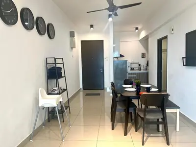 a dining room with a table and chairs and clocks on the wall at Ipoh Town Majestic 3R2B 10paxs Remi Suite in Ipoh