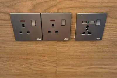 two electrical switches sitting on top of a wooden table at Wi-Fi 100MB free Ipoh Homefeel 4 rooms Tatami S48 in Ipoh