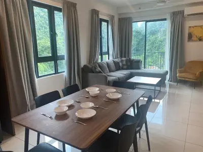 a living room with a wooden table and chairs at Ipoh Tambun Sunway Onsen Suite 3R2B Miya in Ipoh