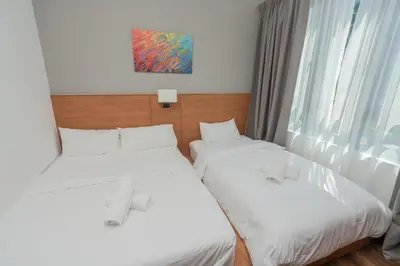 two twin beds in a room with a window at Ipoh Tambun Sunway Onsen Suite 3R2B Maya in Tambun
