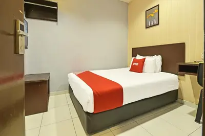 a hotel room with a bed with a red pillow at Hotel O M Three Hotel in Kampong Batu Tiga