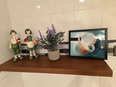 two dolls and a picture on a shelf with a plant at (WI-FI) Ipoh Holiday Big House double storey DR8 in Ipoh