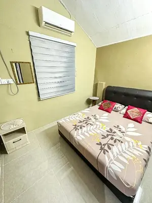 a bedroom with a bed and a window with a window blind at Dusun Indah Cottage 3 in Bayan Lepas