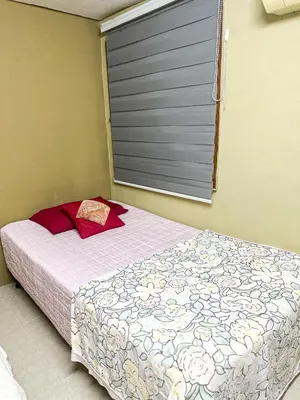 a bedroom with a bed and a window with a flower pattern at Dusun Indah Cottage 3 in Bayan Lepas