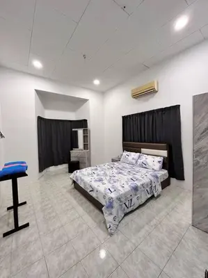 a bedroom with a bed and a table in it at Juzt Homestay Kpg Boyan in Taiping