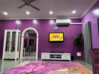 a living room with a purple wall with a tv at ARY&ZZ Homestay for islam guests in Tanjung Karang