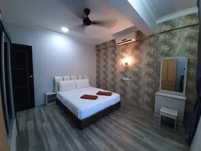 a bedroom with a white bed and a television at Zaque's Hotel in Sungai Petani