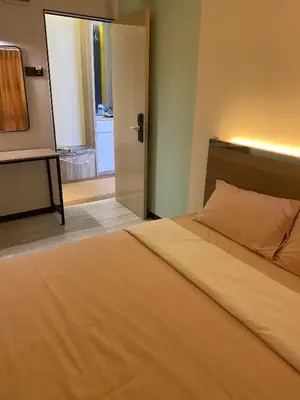 a bedroom with a bed and a door to a bathroom at Clock Inn Backpackers Hostel in Tanah Rata