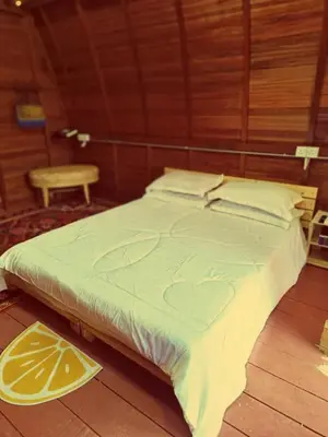 a large bed in a wooden room with at LBA chalet in Balik Pulau