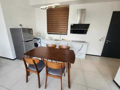 a kitchen with a wooden table and two chairs at Executive Premium Urban Suites - Jelutong in Jelutong