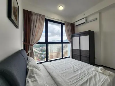 a bedroom with a bed and a large window at Executive Premium Urban Suites - Jelutong in Jelutong
