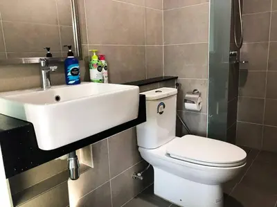 a bathroom with a white sink and a toilet at The ELM, 2BR Cityview by W. Stay @ Tropicana 218 Macalister in George Town