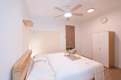 a bedroom with a bed and a ceiling fan at Muji Style 5BR Ferringhi Beach House 15Pax in Batu Ferringhi