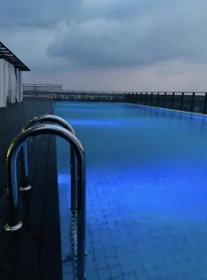 a large swimming pool with blue lights on it at Cozy Suite - Near UTAR - Champs Elysees Kampar in Kampar
