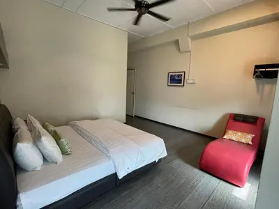 a bedroom with a bed and a red chair at GOPENG INN Homestay in Gopeng