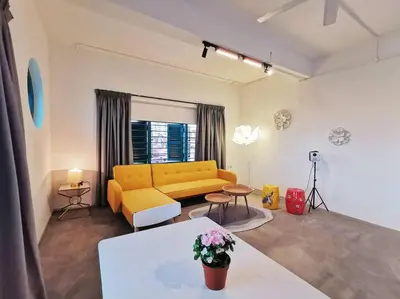 a living room with a yellow couch and a table at Ipoh town centre eastern oriental 8 pax(2BR) in Ipoh