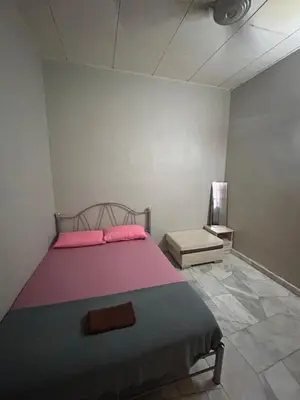 a bedroom with a bed with a pink blanket and a table at Hz Homestay Bertam in Kepala Batas