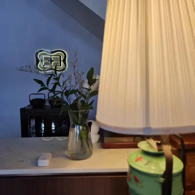 a vase with flowers on a table with a lamp at Betel Nut Lodge in George Town