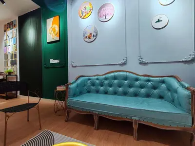 a blue couch in a room with a green wall at Moon Classic Falim by Irainbow in Ipoh