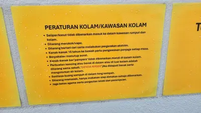 a yellow sign on a wall with text on it at Villa Fatima in Sitiawan