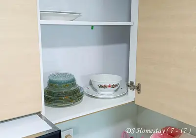 a cupboard with a bowl and a cup and plates at Metropol Serviced Apartment Nice Pool View 3 BR in Bukit Mertajam