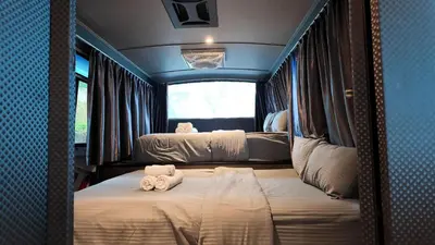a train room with two beds and a window at Campod Resort @ Cameron Highlands in Cameron Highlands