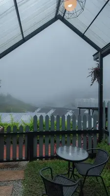 a patio with a table and chairs and a fence at Campod Resort @ Cameron Highlands in Cameron Highlands