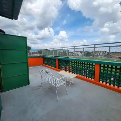 a white bench on a balcony with an orange and green railing at Ipoh town centre -rustic home 4pax (studio 5) in Ipoh