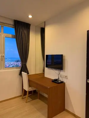 a room with a desk with a television and a window at 118 Apartment Tanjung Tokong by Yen's Sojourn in George Town