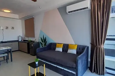 a living room with a couch and a table at Stylish Urban Suite Penang - with infinite pool in Jelutong