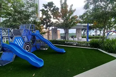 a playground with a blue slide in a park at Stylish Urban Suite Penang - with infinite pool in Jelutong