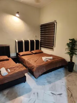 a bedroom with two beds and a potted plant at Sun Star Home by Ipoh Maju Stay in Ipoh