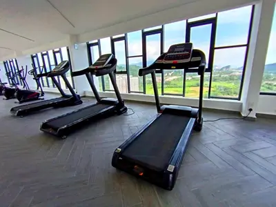 a gym with several treadmills in a room with windows at The Horizon Ipoh 2BR L11 by Grab A Stay in Ipoh