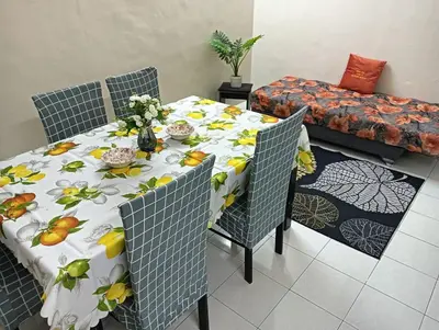 a dining room table with a table cloth with flowers on it at Homestay Itqan Seri Iskandar in Seri Iskandar