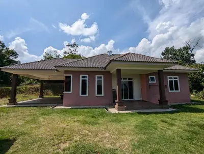 a small house with a green yard at Aish Homestay in Kuala Lipis