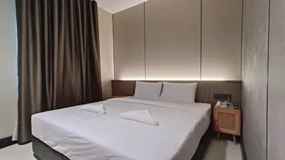 a bedroom with a large bed with white sheets at Urban Inn, Serai Wangi in Padang Serai