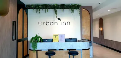 a reception desk in a lobby with a sign that reads urban inn at Urban Inn, Serai Wangi in Padang Serai