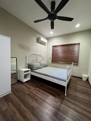 a bedroom with a bed with a ceiling fan at Teratak LS Homestay in Kubang Semang