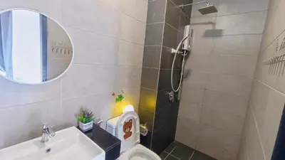 a bathroom with a toilet and a sink and a mirror at Infinity Pool, Georgetown, Up to 11 Pax, 2 Bedrooms, 2 Bathrooms, 2 Car Parks by Star Home in Jelutong