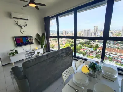 a living room with a couch and a table and chairs at Infinity Pool, Georgetown, Up to 11 Pax, 2 Bedrooms, 2 Bathrooms, 2 Car Parks by Star Home in Jelutong
