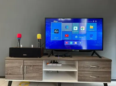a flat screen tv sitting on top of a wooden cabinet at New Brand KTV SET, Netflix, 3 Queen Bed High Floor in Jelutong