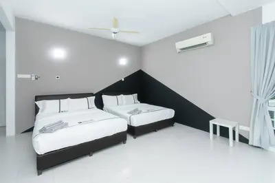 a bedroom with two beds and a window at Beach side spacious 5BR 20pax pool house in Batu Ferringhi