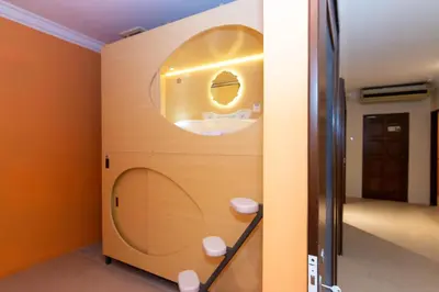 a bathroom with a wall with a circular window at Momostay in George Town